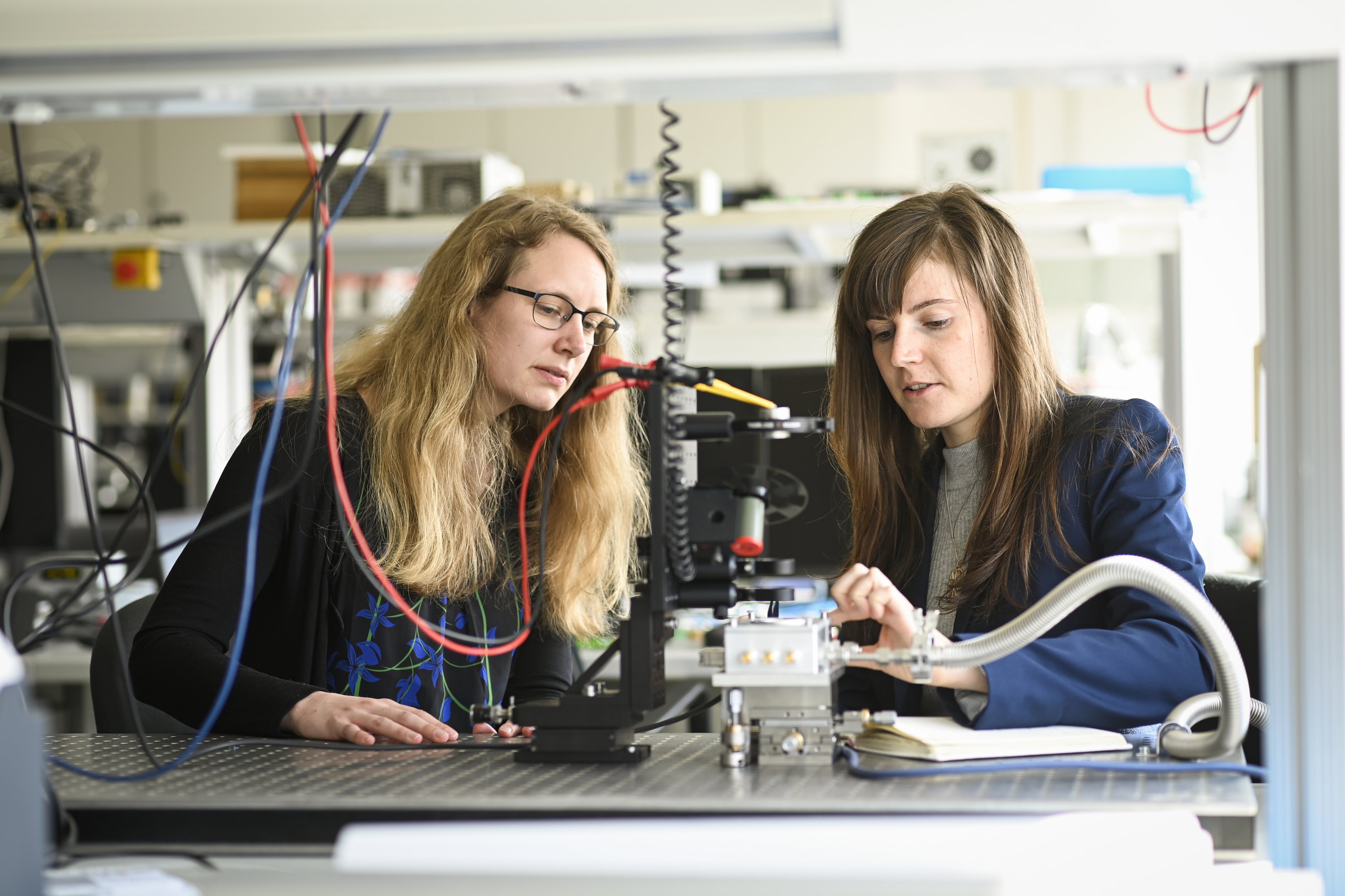 Zwei Forscherinnen vor einem Laboraufbau